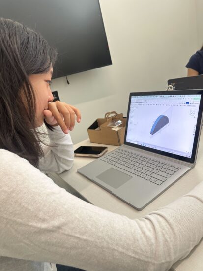 Neutrino team member CADing a part on their computer using Onshape 